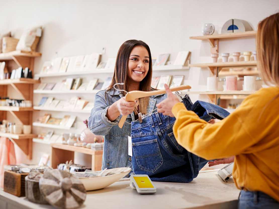 Biträde i klädesbutik betjänar kund